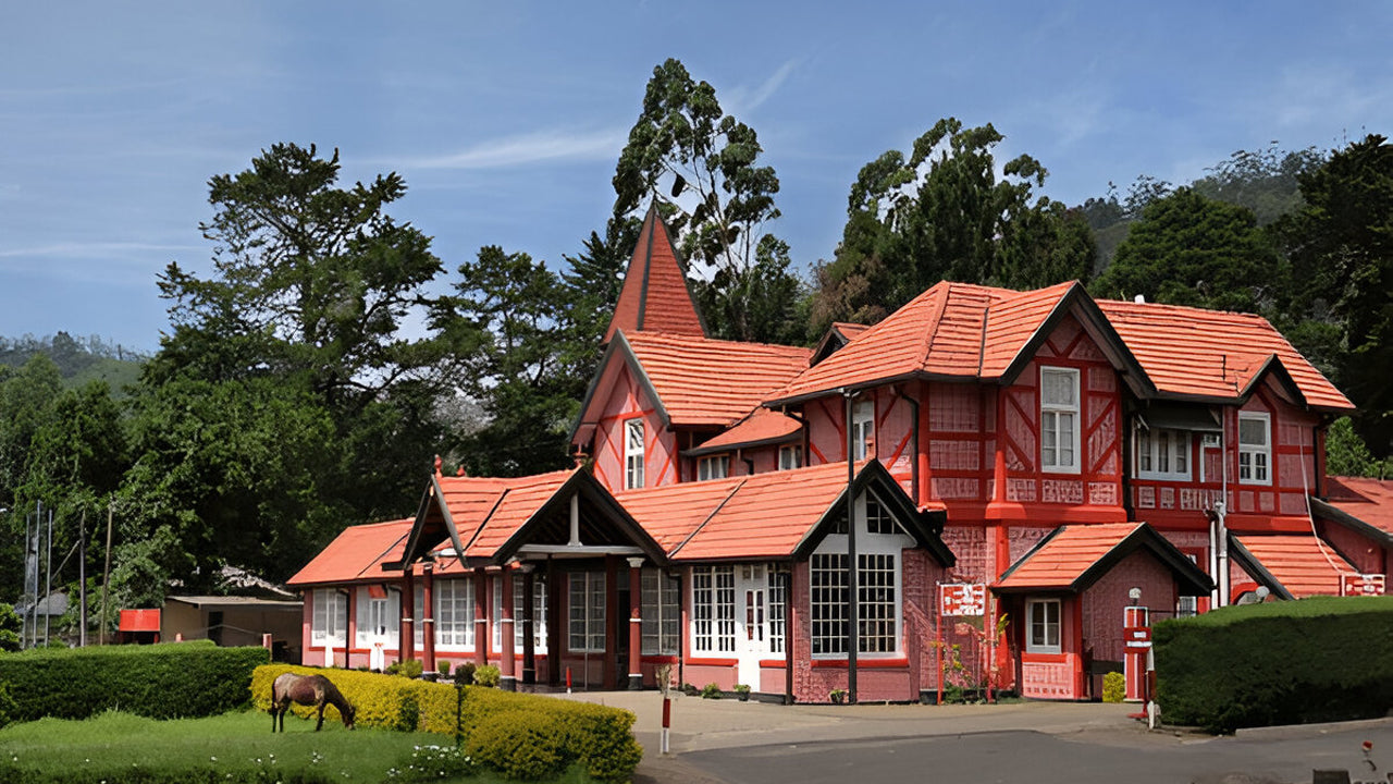 Red wooden building with a tiled roof in a lush green landscape